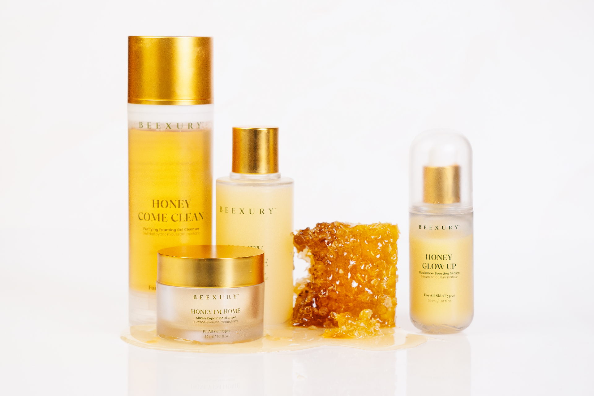 Hand reaching down with Beexury Honey Dazz Me toner above dripping honey and honeycomb